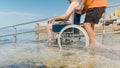 Man on wheelchair on ramp to sea Royalty Free Stock Photo