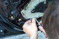 A man disassembles a car door with a screwdriver in order to repair a power window. Car repair at a service station Royalty Free Stock Photo