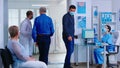 Man discussing with nurse at hospital reception