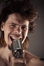 Man with disheveled hair singing into retro microphone Royalty Free Stock Photo