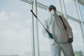 Man disinfector worker cleaning office space and window before work on corona virus pandamia Royalty Free Stock Photo