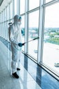 Man disinfector worker cleaning office space and window before work on corona virus pandamia Royalty Free Stock Photo