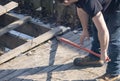 Man Dismantling an Old Wooden Deck with a Red Crowbar 1