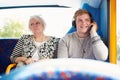 Man Disturbing Passengers On Bus Journey With Loud Music Royalty Free Stock Photo