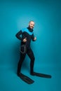 Man in diver wear holding thumb up on blue background Royalty Free Stock Photo