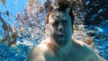 a man dives into the pool with a camera in his hands. shooting under water. Royalty Free Stock Photo