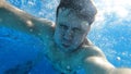 a man dives into the pool with a camera in his hands. shooting under water. Royalty Free Stock Photo