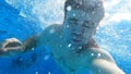 a man dives into the pool with a camera in his hands. shooting under water. Royalty Free Stock Photo