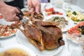 Man divides with scissors freshly baked duck into portions, process close up. Events take place at home during a family meeting to