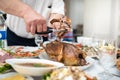 Man divides with scissors freshly baked duck into portions, process close up. Events take place at home during a family meeting to