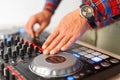 Man DJ plays on the mixing console close-up