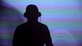 Man DJ silhouette on wall, performing for party, dancing to music, back view