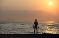 Man do exercise under the sunset, other watch his own stuff, Royalty Free Stock Photo