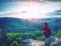 Man do Yoga pose on the rock within orning. Middle-aged sportsman