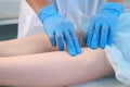 Man doctor acupuncturist in gloves inserts acupuncture needle to woman`s legs.