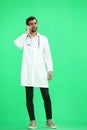 A man doctor conversate with phone on a green background Royalty Free Stock Photo