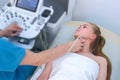 Man doctor examining patient`s woman thyroid gland using ultrasound scanner. Royalty Free Stock Photo