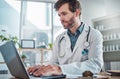 Man, doctor and laptop typing in healthcare research, communication or social media at office desk. Male medical expert Royalty Free Stock Photo