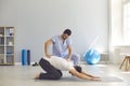 Man doctor osteopath fixing mans back with hands during exersicing on fitness mat