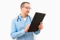 Man doctor pointing with finger at blank paper on clipboard, white background.