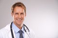 Man, doctor and smile in studio, portrait and medical professional on gray background. Male person, healthcare and pride
