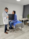 Man doctor specialist neurologist dark-skinned shows brain x-ray to Latin woman patient for tumor or head injury Royalty Free Stock Photo