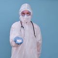 Man in doctor uniform with pills in hands on blue studio background