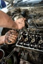 A man does a broach of the head. Makes car repair, engine malfunctioning