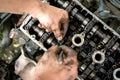 A man does a broach of the head. Makes car repair, engine malfunctioning.