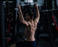 A man does a chest pulldown in the gym.