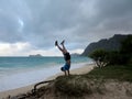 Man does handstand on grassy bluff on Waimanalo beach