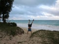 Man does handstand in the sand wearing t-shirt and shorts on the