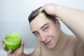 Man does head scrub. Dark-haired young man applies a scalp scrub to combat dandruff, oily scalp, alopecia. Problem skin causing