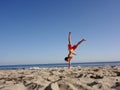 Man does one handed Handstand on beach