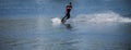 The man does wakeboarding on the water in the summer in a helmet and wetsuit