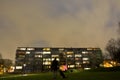 Man with dog in front of a building in a Spooky park at a rainy night Royalty Free Stock Photo