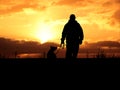 Man and the dog keep headings to the sunset Royalty Free Stock Photo