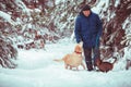 A man with a dog and a cat walks through a snowy forest Royalty Free Stock Photo