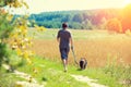 A man with a dog on a leash runs along the road Royalty Free Stock Photo