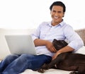 Man, dog and portrait with laptop on sofa for bonding, playing or happiness with remote work in home. Animal, person and Royalty Free Stock Photo