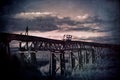 Man and dog in rural scene wander across an abandoned bridge Royalty Free Stock Photo