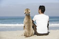 Man And Dog Sitting On Beach Royalty Free Stock Photo