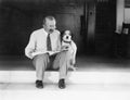 Man and dog sitting on the steps reading the newspaper Royalty Free Stock Photo