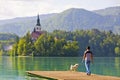 Man with a dog walks on the pier of Lake Bled, Slovenia