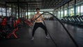 Man doing battle ropes exercise in a fitness gym. Shirtless fitness young sports man training .work out healthy. exhausted, tired Royalty Free Stock Photo