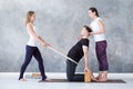 Man doing camel yoga pose in gym with his instructors