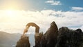 Man doing complex Yoga exercise headstand. Amazing Yoga landscape in beautiful mountains. Dangerous stunts traceur