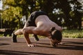 Man doing dive bomber push ups outdoor with face down