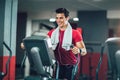 Man doing exercise on elliptical cross trainer in sport fitness gym club