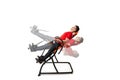 Man doing exercise on inversion table for his back pain, isolated on white. Multiple positions
